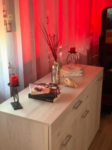 a wooden dresser with red walls and a vase with flowers at Studio Madi - Close to beach in Constanţa