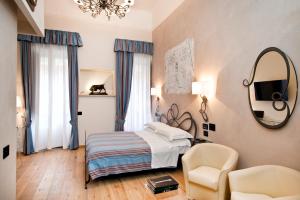 ein Schlafzimmer mit einem Bett, einem Stuhl und einem Spiegel in der Unterkunft Luxury Ripetta 2 in Rom