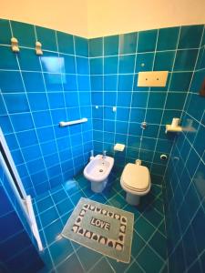 Baño de azulejos azules con aseo y lavamanos en Citai Hill, en San Teodoro