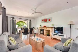 a living room with a couch and a tv and a table at Chalet tranquilo y acogedor a 50 metros de la playa in Cala Blanca