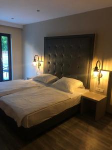 a bedroom with a large bed with two lights on it at Hotel Athen Kelsterbach Frankfurt Airport in Kelsterbach