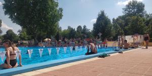 um grupo de pessoas sentadas ao redor de uma piscina em Brasna Apartment 1 - Kupalisko em Nové Zámky