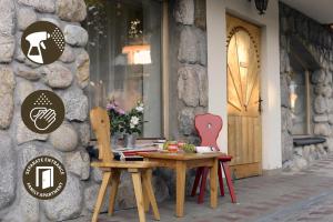 a dining room table and chairs in front of a building at Apartamenty ApartArt Zakopane in Zakopane
