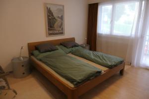 グレヘンにあるHaus Silberblick Anrigのベッドルーム1室(緑のシーツが敷かれたベッド1台、窓付)