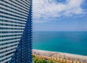 a view of a tall building and a beach at Orbi City Hotel Official in Batumi