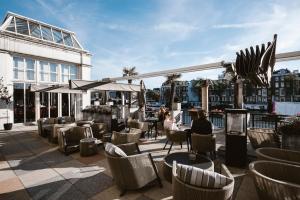 
a patio area with chairs, tables and umbrellas at InterContinental Amstel Amsterdam, an IHG Hotel in Amsterdam
