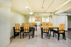 una sala da pranzo con tavoli e sedie in legno di OYO 928 Leaf Hostel a Chiang Mai