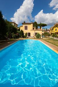 una piscina azul con una casa en el fondo en Appartamento Villa Matone, en Grottaferrata