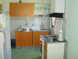 a kitchen with orange cabinets and a stove top oven at Villa Welcome in Vrboska