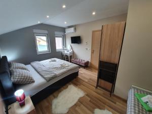 een kleine slaapkamer met een bed en een bureau bij Apartman Božur **** in Satnica Ðakovačka