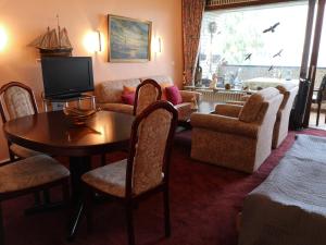 a living room with a television and a table and chairs at Ferienwohnung direkt am Steinhuder Meer in Neustadt am Rübenberge