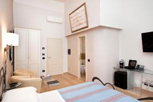 Dieses weiße Zimmer verfügt über ein Bett und einen TV. in der Unterkunft Luxury Ripetta 2 in Rom