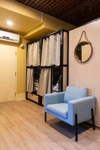 a living room with a blue couch and a mirror at Auberge Jeunesse QBEDS Hostel in Quebec City