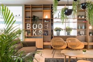カットーリカにあるHotel San Marcoの椅子とテーブル、植物の入った棚のある部屋