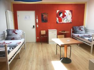 Zimmer mit 2 Betten und einem Tisch in der Unterkunft Die Werkstatt in Dreieich