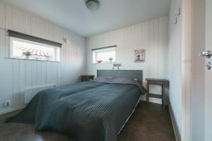 1 dormitorio con 1 cama y 2 ventanas en Hav & Logi Skärhamn en Skärhamn