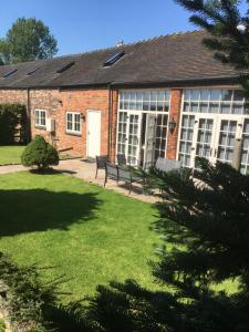 a brick building with a bench in a yard at Moorhen Cottage in Stoke on Trent