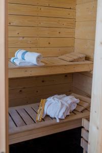 a wooden sauna with two towels and a thermometer at Chalet Bischofsmühle in Helmbrechts