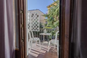 - un balcon avec une table et des chaises sur une terrasse couverte dans l'établissement Rooms Giulietta e Romeo, à Vérone