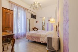 ヴェローナにあるRooms Giulietta e Romeoのベッドルーム1室(ベッド1台、テーブル、シャンデリア付)