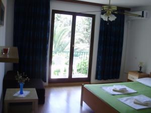 a bedroom with a green table and a large window at Villa Welcome in Vrboska