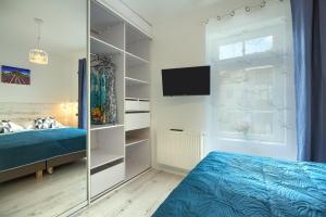 sypialnia z niebieskim łóżkiem i telewizorem w obiekcie Bruno w mieście Krynica Zdrój