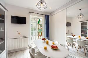 - une salle à manger blanche avec une table et des chaises blanches dans l'établissement Bruno, à Krynica-Zdrój