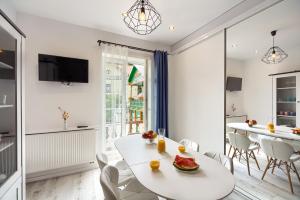 a white dining room with a white table and chairs at Bruno in Krynica Zdrój