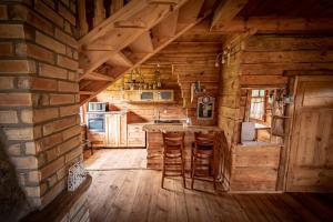 a kitchen with a bar in a log cabin at Siedlisko Matiaszówka in Matiaszówka