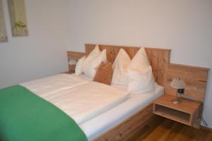 a bed with white sheets and pillows on it at Landhaus Marina in Werfenweng