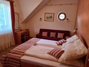 a bedroom with a large bed and a red couch at Apartmaji PEC-Sitar in Ribnica na Pohorju