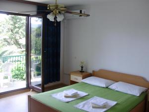 a bedroom with a green bed and a balcony at Villa Welcome in Vrboska