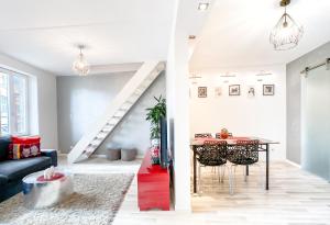 a living room with a table and a staircase at The downtown cosy apartments in Colmar
