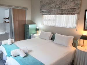 a bedroom with two beds and a window at Whale Watchers Inn in Witsand