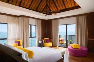 a bedroom with a bed and a view of the ocean at Golden Palm Tree Sepang in Sepang