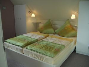 een bed met twee kussens erop bij Ferienhaus Wattenmeerblick in Nordstrand