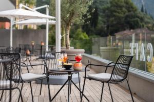 a table and chairs on a balcony with drinks on it at HOODY ACTIVE & HAPPINESS HOTEL in Arco