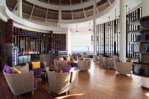 a lobby with a bunch of chairs and tables at Golden Palm Tree Sepang in Sepang