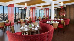a restaurant with red chairs and tables and windows at Golden Palm Tree Sepang in Sepang
