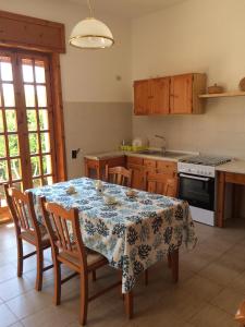 a kitchen with a table with chairs and a tablecloth at La Villetta al Mare in Porto Cesareo