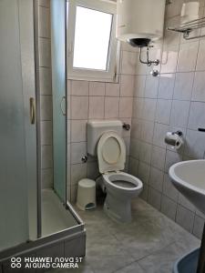 La salle de bains est pourvue de toilettes, d'un lavabo et d'une fenêtre. dans l'établissement Apartmani Bezek, à Ston
