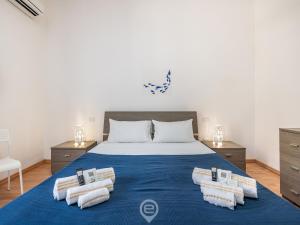 a bedroom with a large bed with towels on it at Manì Rooms Villanova in Cagliari