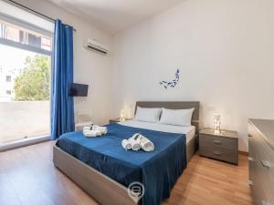 a bedroom with a bed and a large window at Manì Rooms Villanova in Cagliari