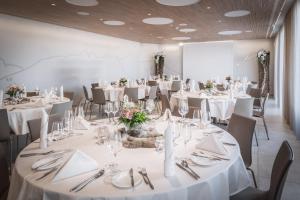 Hotel Buchserhof في بيوشس: غرفة مليئة بالطاولات والكراسي مع طاولات بيضاء