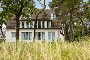 a white house with trees in front of it at Apartmenthaus Seehof in Timmendorfer Strand