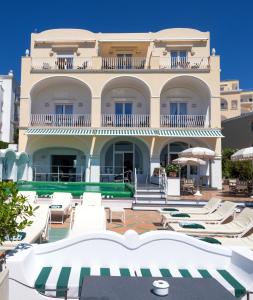 a large building with lounge chairs and a swimming pool at Sina Flora in Capri