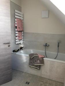 a bathroom with a bath tub and a sink at Gästehaus Brunnenkunst - Exklusiv wohnen im Herzen der Stadt in Arnstadt