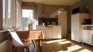 a kitchen with a table and white cabinets and a window at Ferienwohnung am Strandweg in Hohwacht