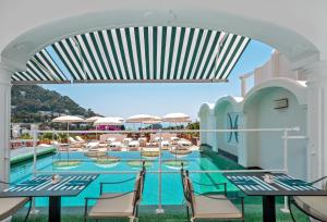 a view of the pool at a resort with tables and chairs at Sina Flora in Capri