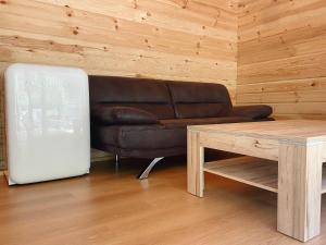 a living room with a leather couch and a table at Camping Piccolo Paradiso in Avegno